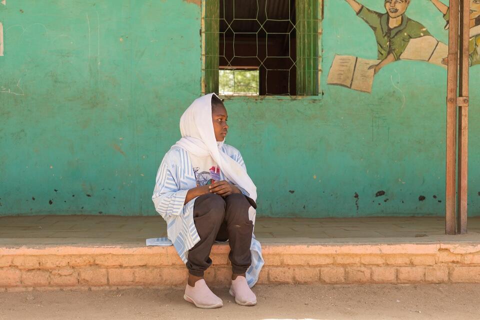 Fifteen-year-old Walaa sits on a classroom veranda at the UNICEF-supported Alshargia safe learning space or Makanna in Kassala state, Sudan..